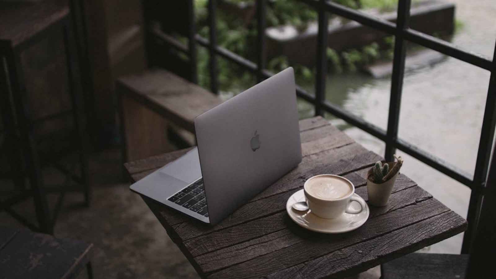 Laptop and coffee on a cafe table in a calm remote-work setting